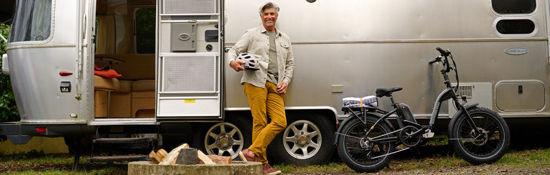 Man stands in front of airstream trailer with folding ebike.