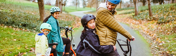 A family poses on their RadWagon and RadRunner in a lush Seattle park.