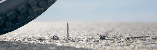 A close-up of a bike tire approaching a nail