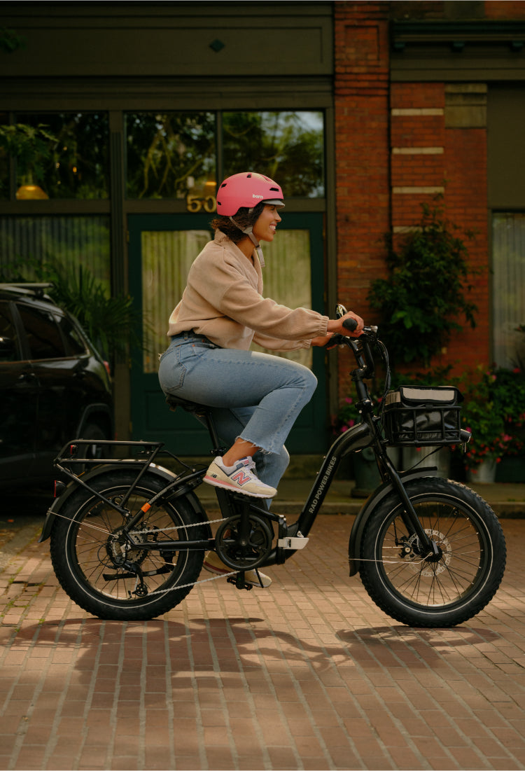 Woman wearing a pink helmet riding an electric bike