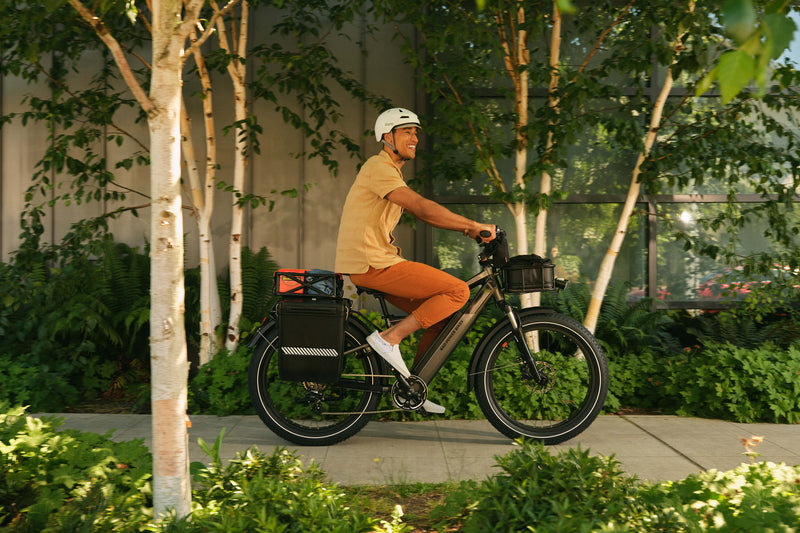 Man riding an electric fat tire bike with multiple storage accessories, including the harshell locking pannier. 