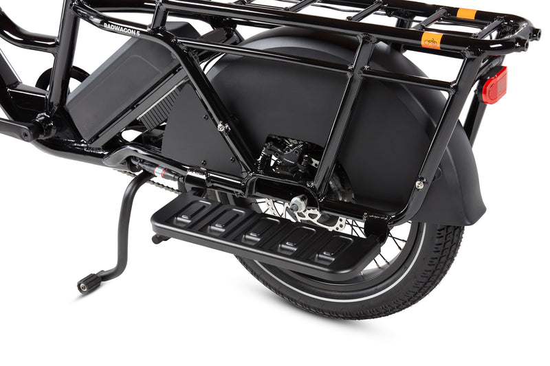 RadWagon Running Boards shown installed on the left side of a RadWagon 5 electric cargo bike. Cast aluminum foot boards that attach to the ebike and allow a passenger to rest their feet.